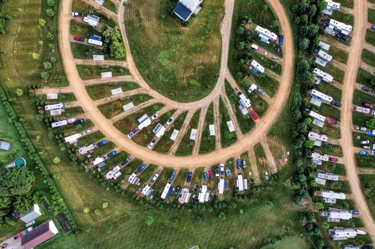 Luchtfoto van een camping met caravans tussen de bomen