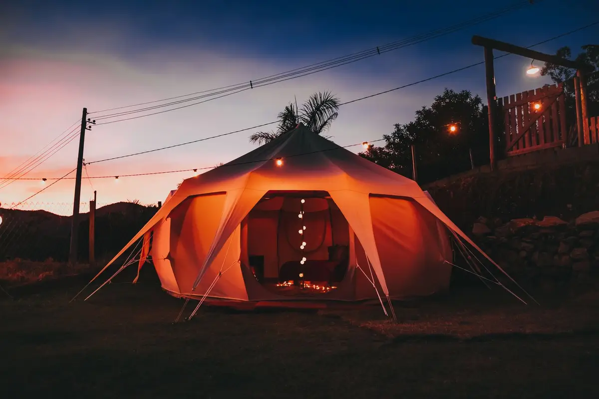 Verlichte glampingtent in de avondschemering